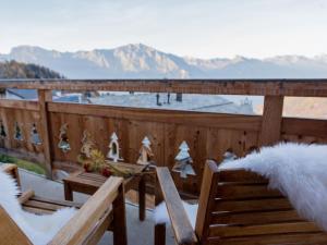 a snow covered deck with benches and mountains in the background at Chalet Petit Sapin in La Tzoumaz