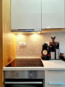a kitchen with white cabinets and a stove top oven at Apartman BJANKA in Budva