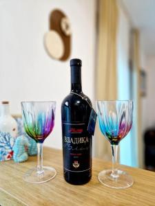 a bottle of wine and two glasses on a table at Apartman BJANKA in Budva