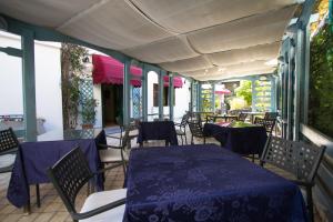 a patio with tables and chairs with blue table cloth at Hotel Marinella in Celle Ligure