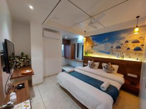 a bedroom with a large bed with a painting on the wall at Hotel The Grand Piano - Best Business Hotel in Patan in Pātan