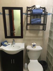 un bagno con lavandino, water e specchio di Mamacitas Guest House a Culebra