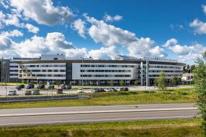 a large office building with a highway in front of it at Quality Airport Hotel Gardermoen in Gardermoen