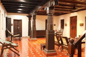 a room with chairs and a pole in the middle at Willo Stays Luxe Heritage Home , Udupi in Udupi