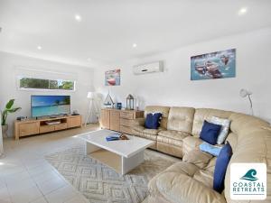 a living room with a couch and a tv at Town & Tide, Cowes Central in Cowes