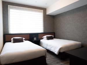 Postel nebo postele na pokoji v ubytování Hearton Hotel Kita Umeda