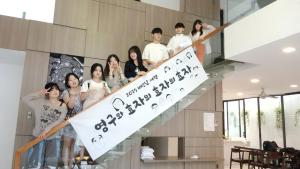 a group of people standing on a staircase with a sign at Charming Luxury Beach Villa Da Nang in Da Nang