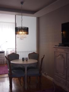 una sala da pranzo con tavolo, sedie e lampadario pendente di SKWER 40 a Gdynia