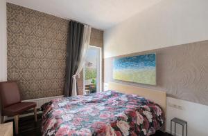 a bedroom with a bed and a chair and a painting at Ferienwohnung 'an der Ostsee' in Mechelsdorf