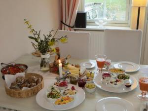 uma mesa com pratos de comida e uma vela sobre ela em Bettis em Tostedt