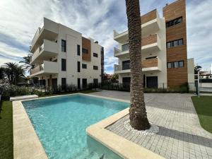 een gebouw met een palmboom naast een zwembad bij Barnuevo 3 in Santiago de la Ribera