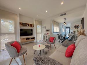 een woonkamer met een bank, stoelen en een tv bij Barnuevo 3 in Santiago de la Ribera