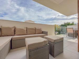 een patio met een bank en 2 tafels op een balkon bij Barnuevo 3 in Santiago de la Ribera