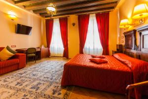 a bedroom with a bed and a couch and red curtains at Casa Wagner in Braşov