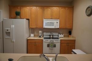 a kitchen with a white refrigerator and a microwave at Universal Studios Area Apartment in Orlando