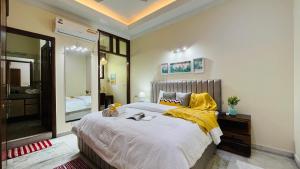 ニューデリーにあるOlive Service Apartments - Green Parkの大きなベッドと大きな鏡のある寝室