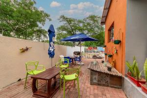 a patio with a wooden table and chairs and an umbrella at Woodpecker's Guest House in Hazyview