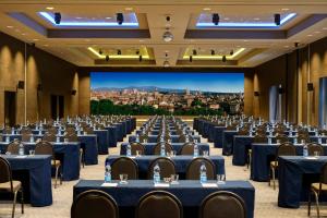 a large banquet hall with blue tables and chairs at A.Roma Lifestyle Hotel in Rome
