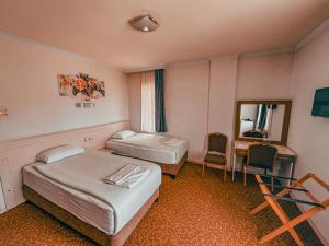 a room with two beds and a desk and a mirror at Oreko Express in Afyon
