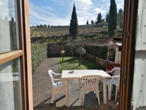 a table and chairs with a view of a yard at Agriturismo Borgo Stella in Montagnana Val di Pesa +3 photos