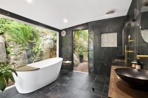 bagno nero con vasca e lavandino di Berowra Waters Glass House a Berrilee Altre 69 foto