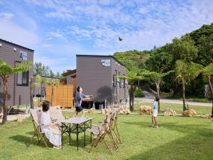 a group of people playing with a ball at a table in a yard at Yambaru Experience Hotel Nunganiku in Higashi
