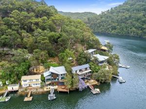 una vista aerea di una casa su un'isola in acqua di Berowra Waters Glass House a Berrilee