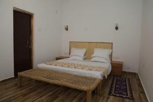 a bedroom with a large bed with a wooden floor at Neels Camp Resorts in Panna