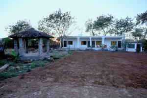 a white house with a gazebo in a field at Neels Camp Resorts in Panna