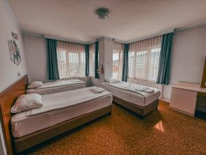 a room with three beds and a window at Oreko Express in Afyon