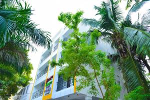 a building with palm trees in front of it at Nilton Bay Residency in Kottakupam