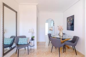 a dining room with a table and chairs and a mirror at Azalea - Stylish Apartment with Rooftop & Pool in Los Altos
