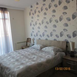 - une chambre dotée d'un lit avec un mur à motifs dans l'établissement Apartment With Terrace in Avlabari, à Tbilissi