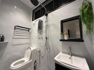 a bathroom with a shower and a toilet and a sink at Mujito3 4BR 16PAX InTown, PoolTable, PS4, Netflix in Kuantan