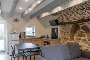 a kitchen with a table and a brick wall at studio proche zenith et clinique in Saint-Herblain