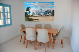 a dining room table and chairs with a painting on the wall at JASMIN MWT MUNICH ---800 Meter zum Strand-Sea-Beach in Djerba
