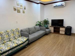 a living room with a couch and a flat screen tv at Thảo Nguyên Hotel in Kinh Dinh