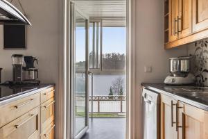 a kitchen with a large glass door leading to a balcony at Ronneby Torneryd Retreat in Ronneby