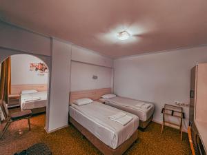 a room with two beds and a table and a chair at Oreko Express in Afyon