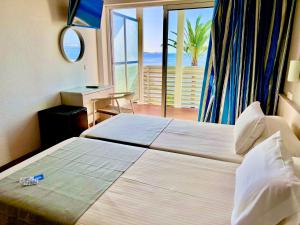 Postel nebo postele na pokoji v ubytování Hotel Neptuno