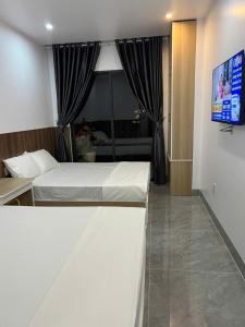 a hotel room with a bed and a television at Hải Nam Homestay Cam Lâm in Cam Lâm