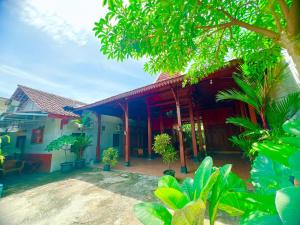 a house with a red roof and some trees at Homestay Omah Joglo in Gading