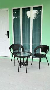 two chairs and a glass table on a patio at The zign in Ko Yao Yai +1 photo