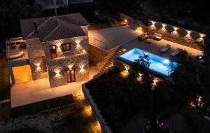 an aerial view of a house at night with lights at Orraon Luxury Villa - Exclusive retreat with panoramic views and infinity pool in Lefkada