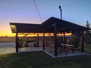 a pavilion with a picnic table and a sunset at Puhkemaja Peretuba in Obinitsa
