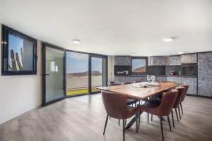 Una cocina y un comedor con mesa y sillas de madera. en Volcanoa, en Villaverde