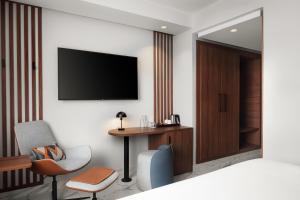 a hotel room with a desk and a television on the wall at Courtyard by Marriott Casablanca Downtown in Casablanca