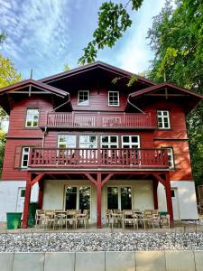 a red house with tables and chairs in front of it at Haus Elim für Gruppen und Großfamilien in Heringsdorf