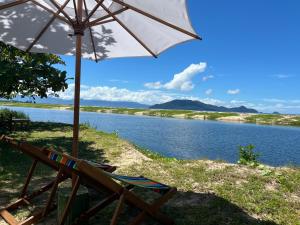a chair and an umbrella next to a river at L hippocampe in Maroantsetra Airport +14 photos