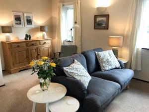 a living room with a blue couch and a vase of flowers at Melbreak in Lorton